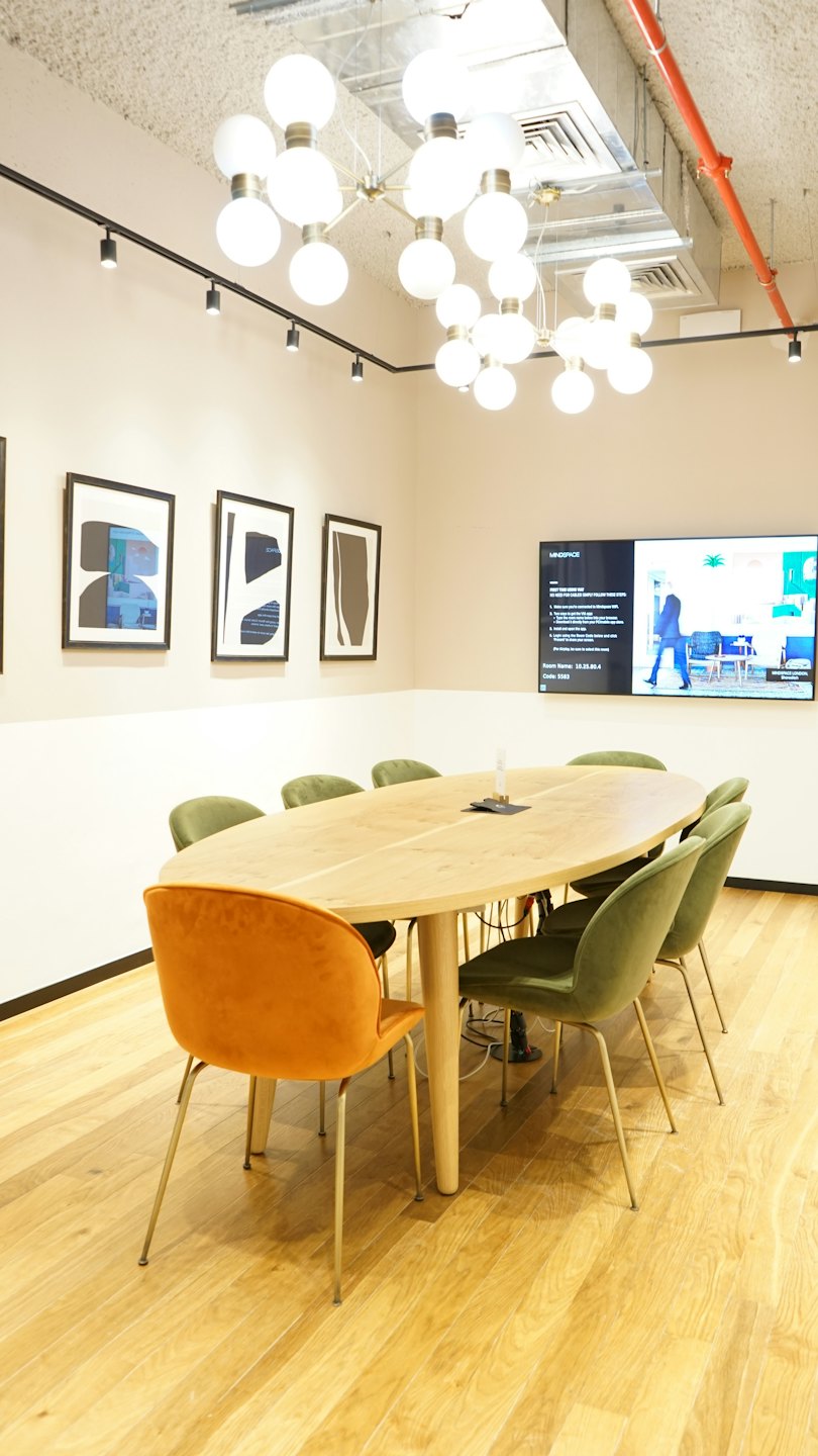 Sala riunioni moderna con tavolo ovale e sedie in velluto.